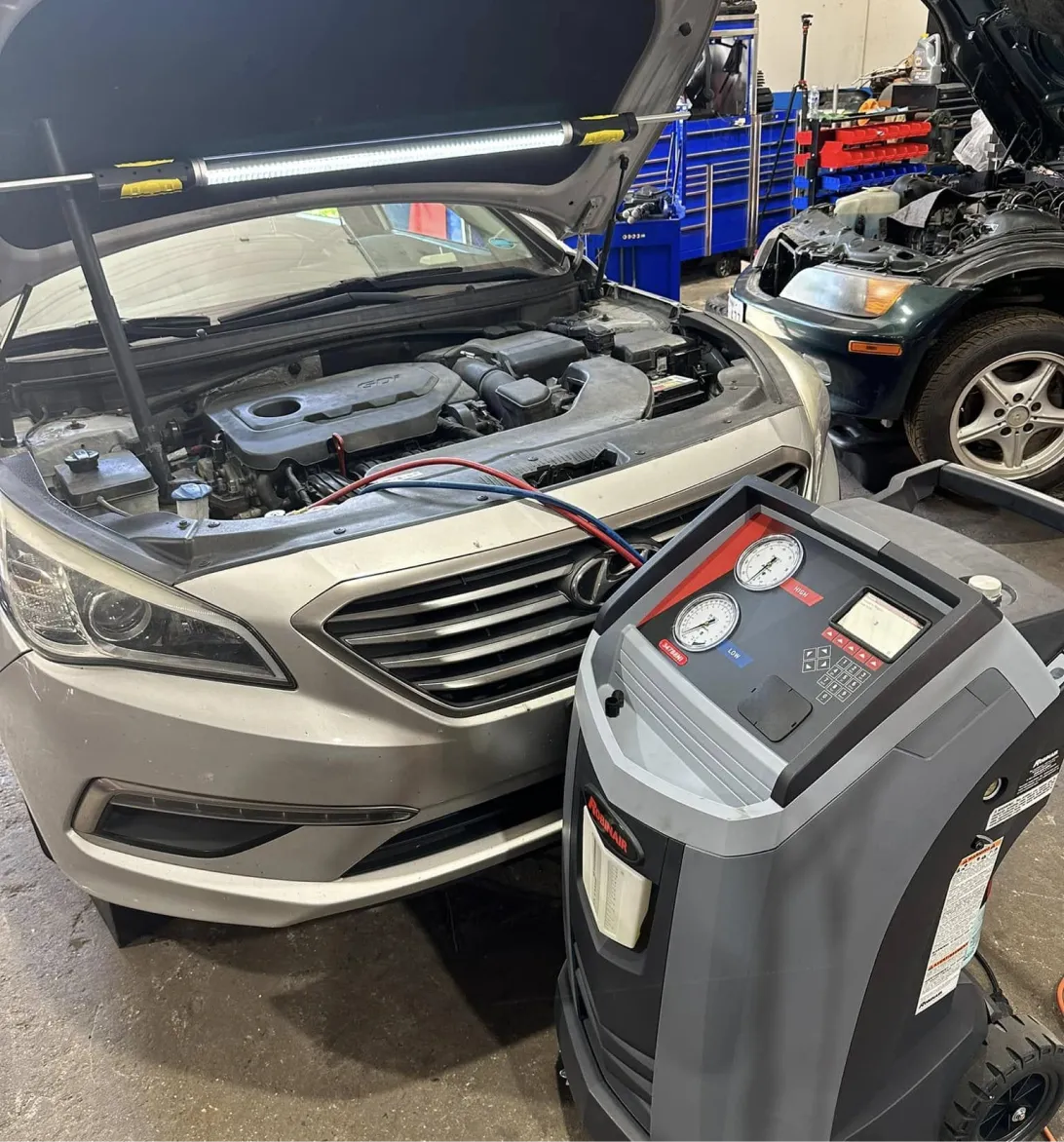 A/C & Heater Repair in Woodbine, MD At KIT'S Auto and Truck Repair. Image of an auto A/C recovery and recharge machine connected to a car for A/C and heater repair